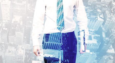 Business person standing with blue cityscape in the background