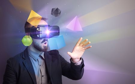 Amazed businessman with virtual reality colorful geometric shapes in front of him