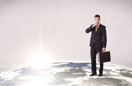 A young elegant office worker standing on top of a drawn world globe while celebrating his successful career concept.