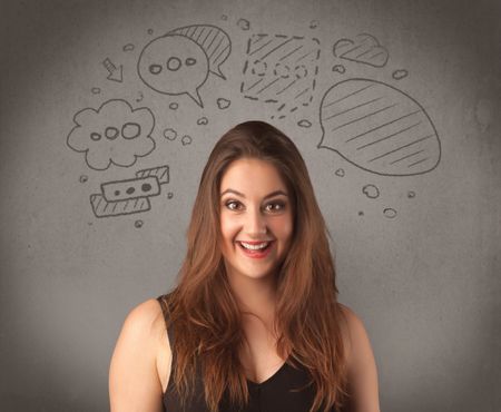 A cute female student making funny expressions with thoughts in her head illustrated by drawn chat bubbles on the urban wall background concept.