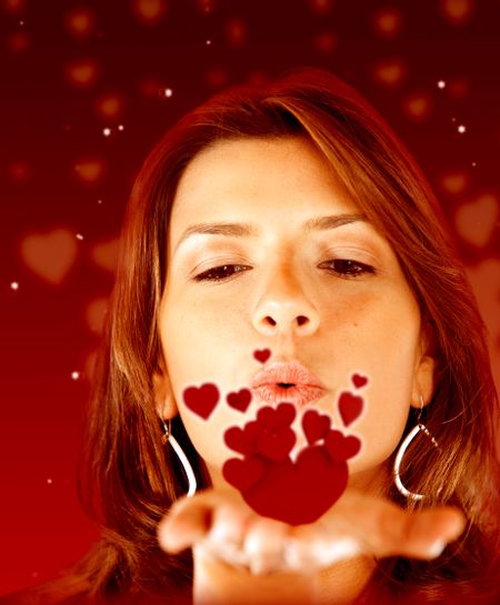 Beautiful woman in love blowing red hearts
