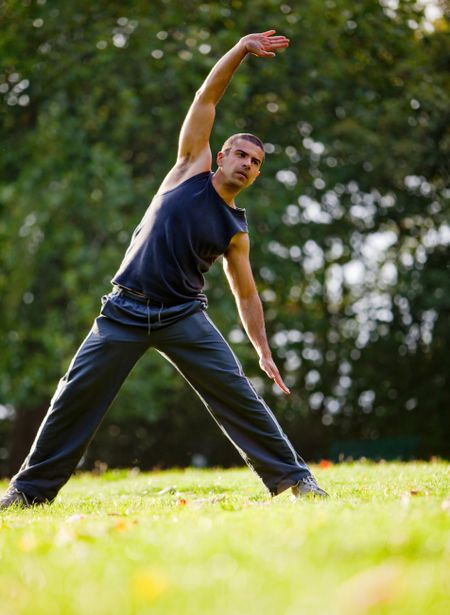 Handsome man stretching at the park - fitness concepts