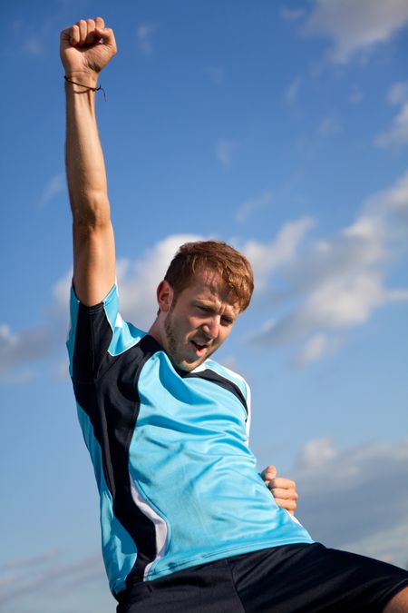 Football player celebrating with arms up outdoors