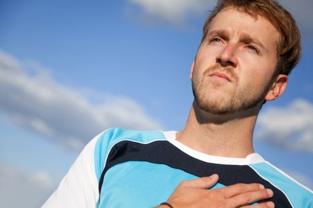 Man outdoors with his hand on heart taking an oath