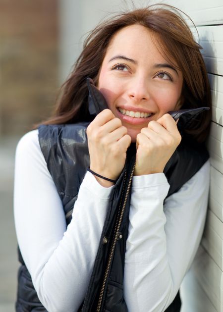 Portrait of a woman feeling cold outdoors holding her vest