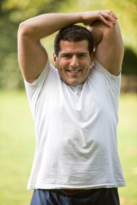 Handsome man stretching at the park - fitness concepts