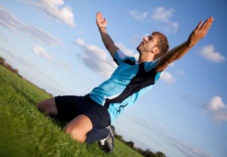 Football player celebrating with arms open outdoors