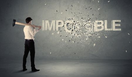 Business man hitting impossible sign with hammer on grungy wall