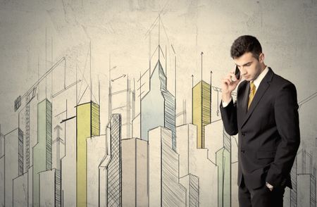 A young adult businessman standing in front of a wall with colorful drawings of buildings, charts, graphs, signs