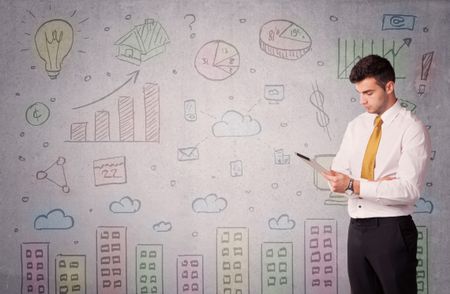 A young adult businessman standing in front of a wall with colorful drawings of buildings, charts, graphs, signs concept