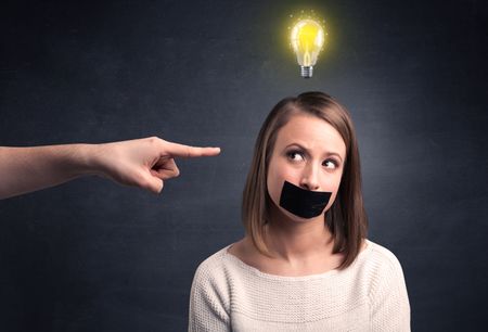 Caucasian hand pointing at female employee with a lightbulb above her head