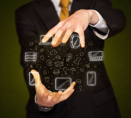 Businessman holding icons related to devices and communication 