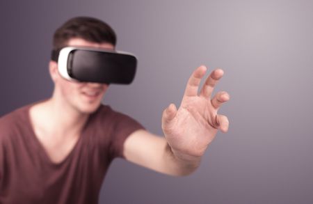 Young impressed man wearing virtual reality goggles