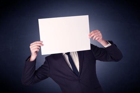 Young businessman hiding behind a blank piece of paper