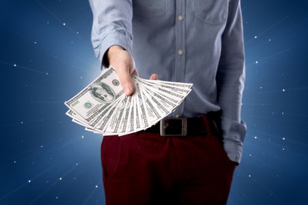 Young businessman holding large amount of bills with light beams behind him