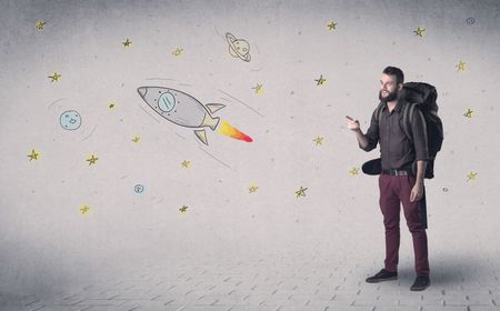 Handsome young man standing with a backpack with space related drawings in the background