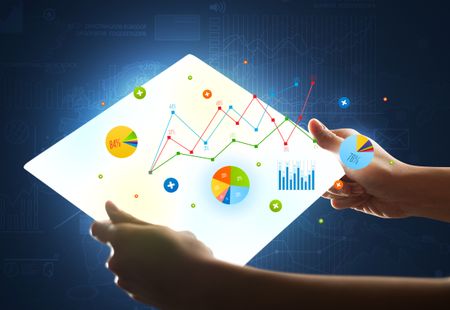 Young female hand holding a tablet with colorful charts