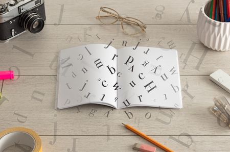 Open notebook on the floor with office instruments nearby and letters on it