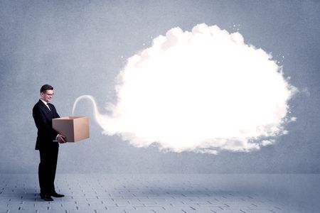 A young cheerful business person holding a cardboard box with illustration of white empty cloud concept.