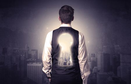 Young businessman standing and thinking with keyhole on his back and city graphic around