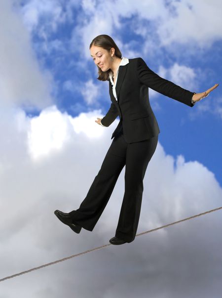 beautiful business woman balancing on rope with the sky at the background