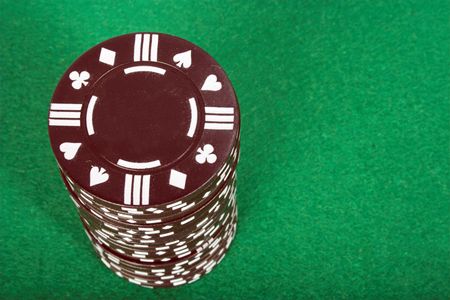 brown casino chip over a green background