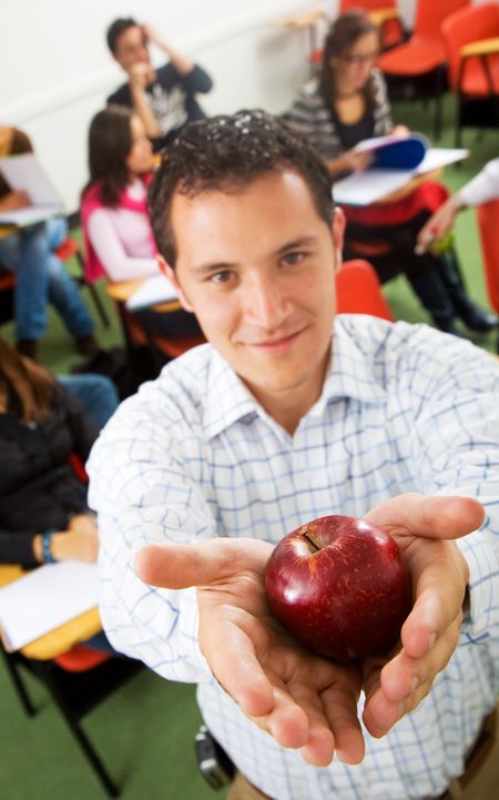classroom and teacher holding an apple in his hands