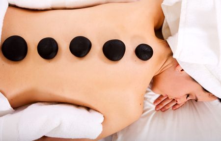 beauty and spa girl with volcanic zen stones on her back