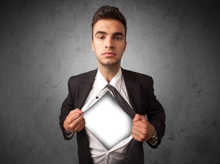 Businessman tearing off his shirt with white copyspace on chest on grungy background