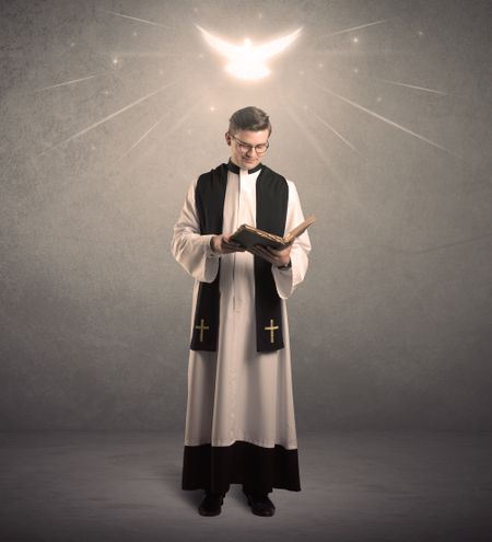 A holy priest reading a prayer from the holy bible with illustrated glowing angel above his head concept.