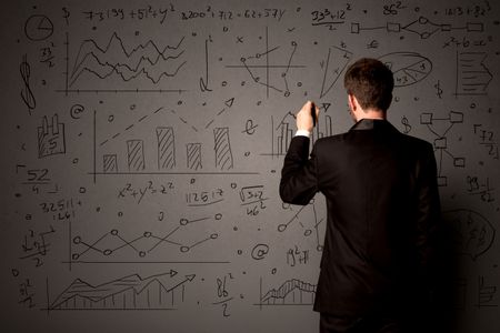 Young businessman in black suit standing in front of detailed calculations