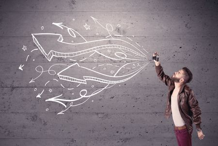 A hipster guy opening his point of view through looking a vintage camera concept with illustratied drawn arrows on urban wall