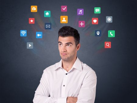 Young casual businessman with colorful applications over his head