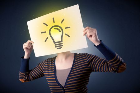 Young casual woman hiding behind a lightbulb drawn on paper