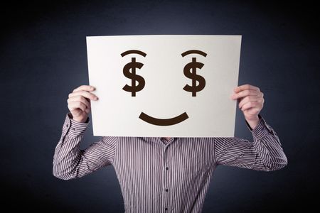 Young casual businessman hiding behind a greedy face drawing on cardboard