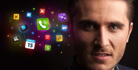 Portrait of a young businessman with colorful applications next to him on a dark background