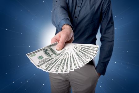 young-businessman-holding-large-amount-bills-626447360 Young businessman holding large amount of bills with light beams behind him