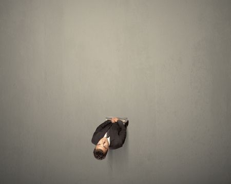 Young businessman contemplating a decision standing on a grey surface