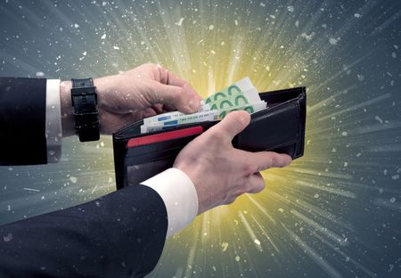 Businessman hand takes out dollar from wallet with fireworks and grungy background