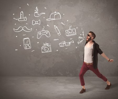 A funny hipster person in casual urban clothing shouting drawn everyday items like camera, tie or pen on city wall concept