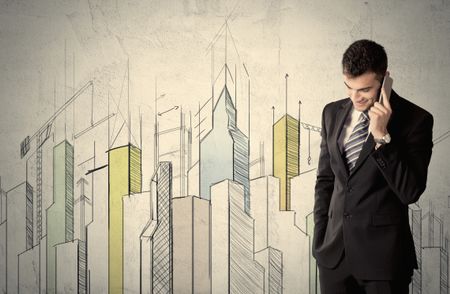 A young adult businessman standing in front of a wall with colorful drawings of buildings, charts, graphs, signs
