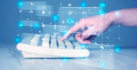 Hand pressing keyboard with high tech media icons and symbols