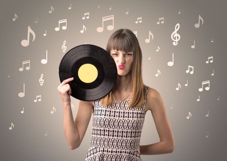 Young lady holding vinyl record on a brown background with musical notes behind her