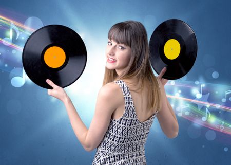 Young lady holding vinyl record on a blue background with musical notes behind her