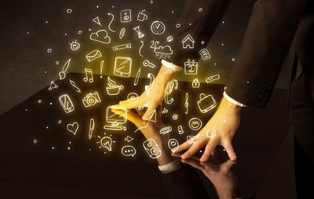 Male hands touching interactive table with yellow mixed media icons on it