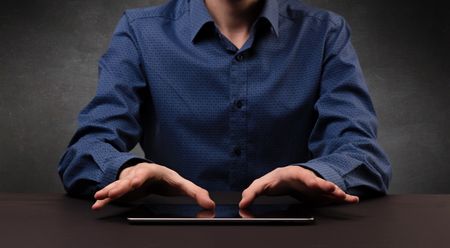 Businessman in suit typing with dark background