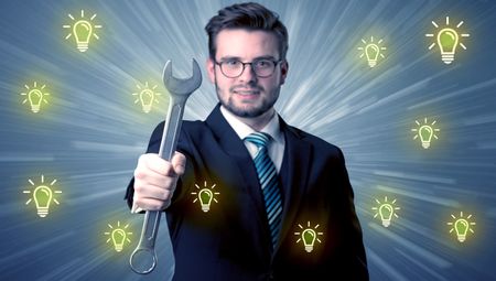 Better-looking businesman holding tool with idea bulbs concep