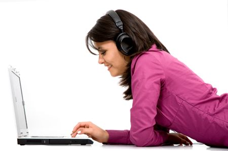 casual female student in purple clothing listening to mp3 music on a laptop computer isolated over a white background