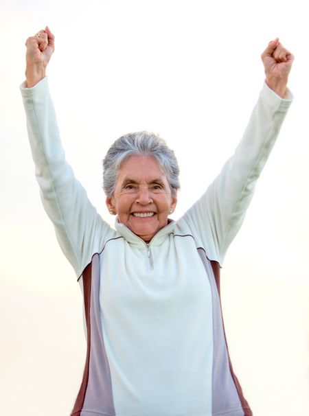 Happy elder woman with arms up and smiling