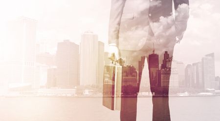 Businessman standing at cityscape background with warm light